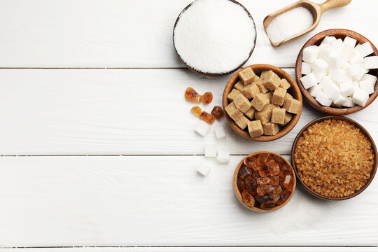 Different types of sugar on white wooden table, flat lay. Space for text