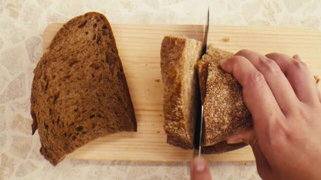 Black rye bread close up, dark brown sliced loaf, borodinsky slavic food, square slices with coriander on white background