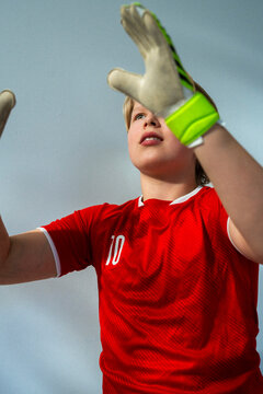 Boy in red soccer jersey practicing goalkeeper skills
