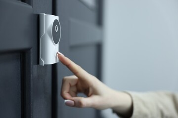 Naklejka premium Woman pressing button on intercom panel indoors, closeup