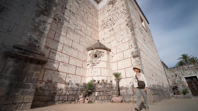 Mature woman walks around the Mission Church in San Ignacio Baja California Mexico taking in the sights and enjoying her trip