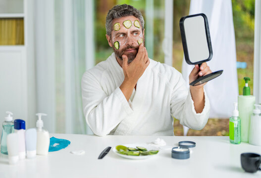 Man applying facial mask with cucumber. Facial mask of cucumber. Cosmetic procedure man with cucumber slices mask on face. Hispanic man with facial cucumber mask. Benefits of vitamin C. Skincare time