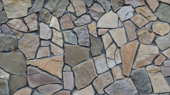 Decorative stone cladding for interior or exterior design using natural, large-size, lightly processed rock. Beautiful stone mosaic texture with randomly arranged cobblestones.