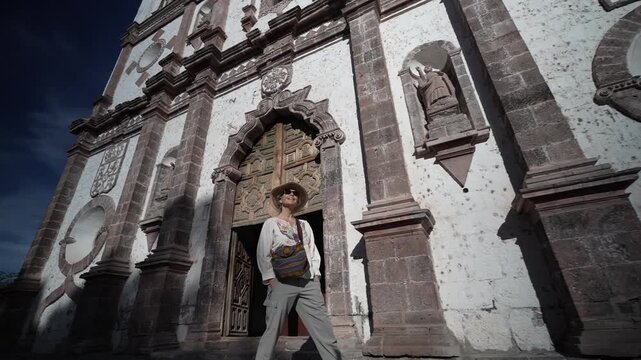 A mature woman explores Mission Church in San Ignacio, Baja California, admiring the architecture and surroundings.