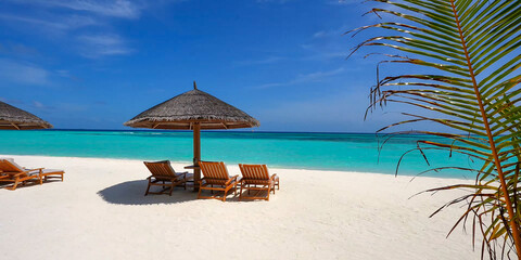 Idyllic tropical beach with white sand, turquoise water, wooden sunbeds under a thatched umbrella, and palm leaves in the foreground © NORMA