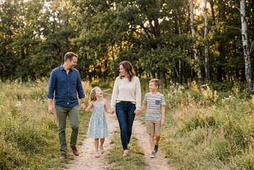 Fototapeta premium Family walking together on path in sunny park