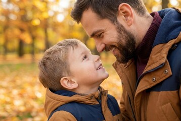 Fototapeta premium Father and son sharing a tender moment, looking into each other's eyes amidst autumn foliage.