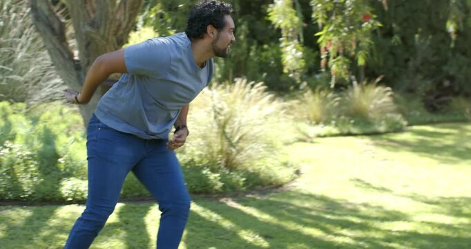 Parents chasing child after child dashing past man, woman in yellow top running on grassy lawn