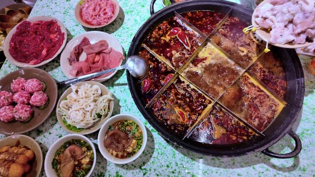 A distinctive spicy mala soup, or hot pot, from Chengdu, China. Various ingredients are added to the simmering, spicy broth, such as sliced pork with bean sprouts.