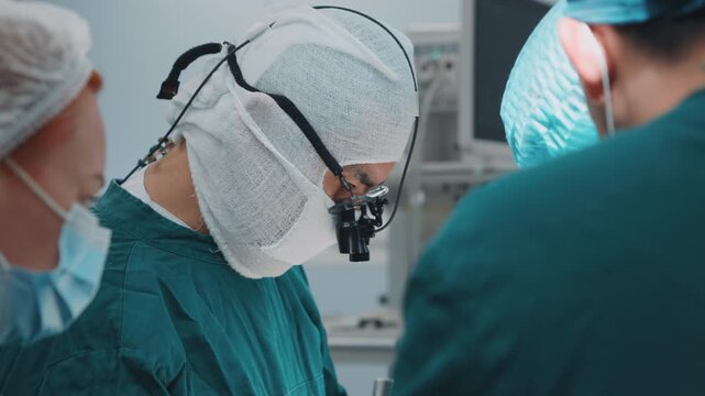 Medical specialists performing complex procedure under operating lights in modern clinic, focused healthcare team working with surgical instruments in sterile environment