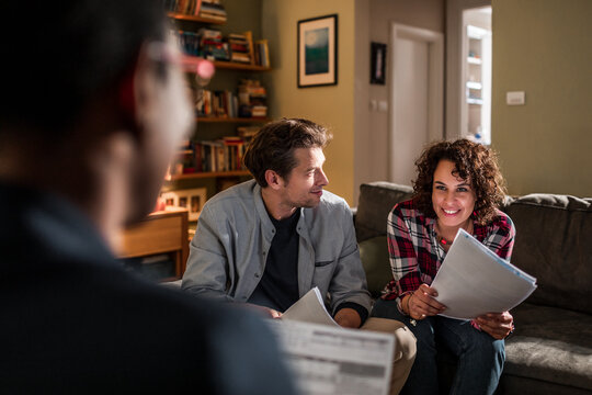 Smiling couple meeting financial advisor at home