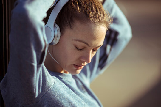 Young woman listening to music outdoors before workout