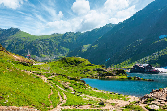 beautiful alpine scenery of fagaras mountains. balea lake in romania mountain landscape. summer weather with clouds on sky. view of rippled water near rocky slope. remote wilderness travel background