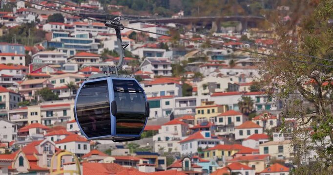 Funchal city cable car cabin moving along the steel wire above the building roofs and houses. Scenic travel attraction in Madeira island, Portugal video