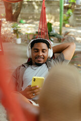 Person listening to music engaging with handheld device © Djavan Rodriguez