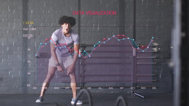 Male trainee starting wide driving battle ropes for fitness slowing data overlaying coach entering