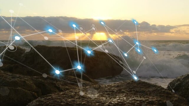 After sun lowering, waves crashing while node network emerging and pulsing, showing data over rocks