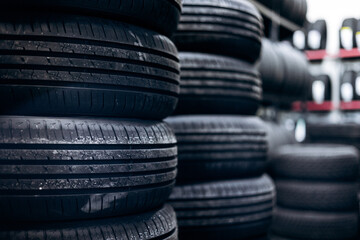 Stacks of used and new car tires and wheels on shelves in an auto service garage, ready for maintenance and replacement © Petro