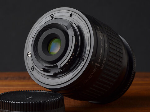 PERPIGNAN, FRANCE - MAY 6, 2026: A Nikon Nikkor 28-80mm f3.3-5.6 G zoom lens on a wooden surface. A compact and lightweight photographic lens for digital and film SLR cameras