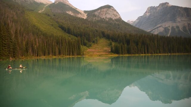 Yoho, Canada - 2 apr 26: Two people paddling a canoe on the turquoise Emerald Lake, Yoho National Park, Canada. Road trip in Canada. Rocky mountains. 4k footage