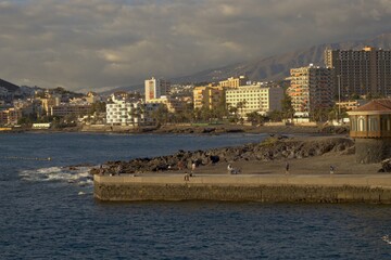 Obraz premium Scenic Coastal City Skyline with Mountains at Sunset in Los Christianos, Tenerife.