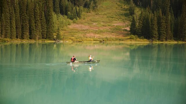 Yoho, Canada - 2 apr 26: Two people paddling a canoe on the turquoise Emerald Lake, Yoho National Park, Canada. Road trip in Canada. Rocky mountains. 4k footage