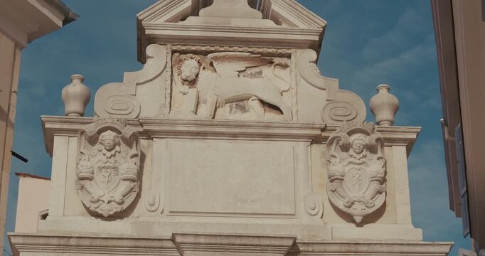 Balbi's Arch with winged lion relief and stone coats of arms on Marshal Tito Square in Rovinj, Istria, Croatia during the morning.