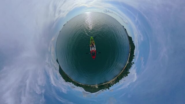 Top View of Woman and Man Kayaking on Ocean with Circular Planet Hole Effect, 360 Degree Perspective Showing Surrounding Coastline, Real Time Immersion and Aerial Travel Experience
