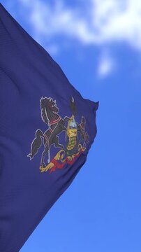 Pennsylvania State Flag Waving Against Bright Blue Sky With Clouds