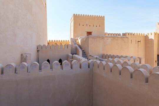 Minimalist desert architecture background featuring the smooth clay walls of Nizwa Fort in Oman. Clean lines, warm beige tones, and empty space create a calm, abstract composition