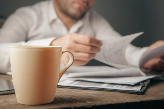Businessman working with papers and a cup of coffee on the table