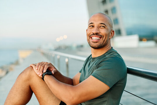 Portrait opf a young man prepering to exercise and looking at watch in sportwear posing for a portrait outdoors