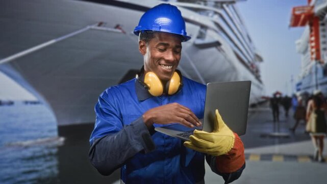 Man construction worker holding laptop and touching chin with gloved hand on a street near a ship terminal; focused productivity.
