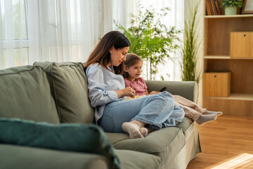 Obraz premium Mother and child relaxing watching television with popcorn
