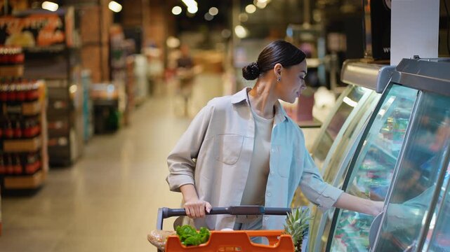 Woman choosing fresh fish in supermarket grocery section