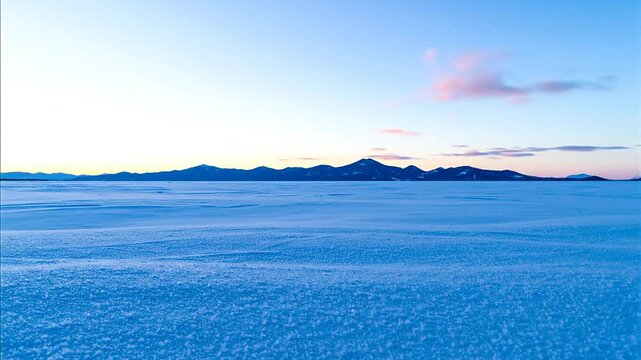 Serene landscape of vast blue terrain at sunset.