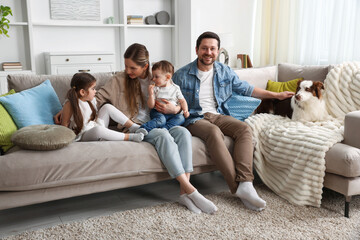 Obraz premium Happy family and their dog on sofa at home