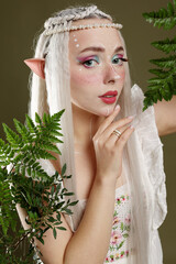 Naklejka premium Beautiful elf girl with floral decor on dark olive background