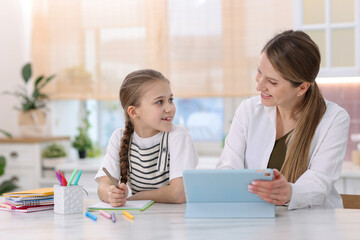 Fototapeta premium Mother and daughter using tablet for studying at home