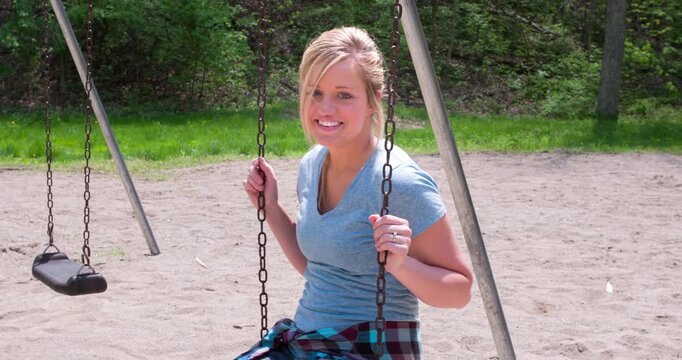 Girl on swing smiling 4k
