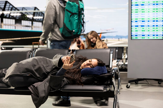 Resting, phone and bored girl in airport telling family about arriving late home for holidays. Using smartphone, flight delay and annoyed woman in departure terminal texting boyfriend