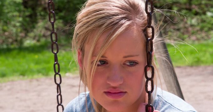 Female on swing looking depressed 4k
