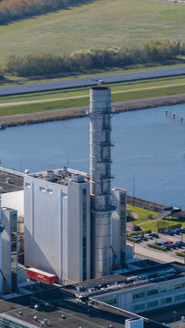 Aerial view of the ENGIE Maxima plant with its tall chimney and industrial buildings near the water in Lelystad, Flevoland, Netherlands.