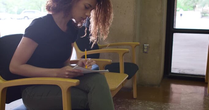 Female writing in notepad at university 4k
