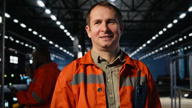 Portrait of factory engineer monitors automation tools in a production plant, mechanical craftsmanship and manpower in industrial environment with heavy construction activity.