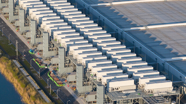 Aerial view of the Google data center with rows of cooling units and large industrial buildings along a canal in Eemshaven, Groningen, Netherlands.