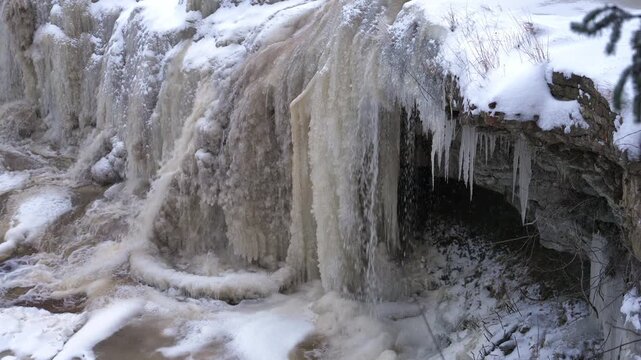 Keila Waterfall in Estonia during winter, frozen cascades and intricate ice formations on a fro