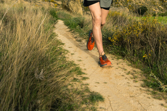 Person trail running on dirt path in nature