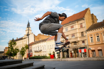 Skateboarder performing an ollie trick in city square © Zoran Jesic