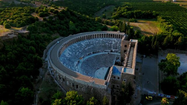 Aerial view inside Aspendos Theatre. Drone shot shows semicircular seating rows and stage area of the ancient Roman landmark.